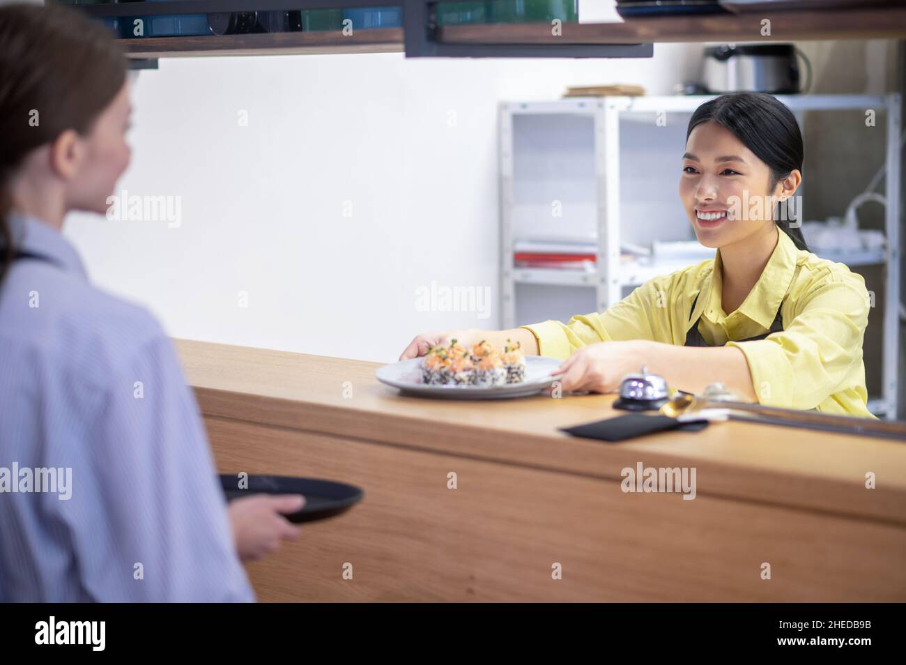 Serveuse asiatique servant des sushis au client Banque D'Images