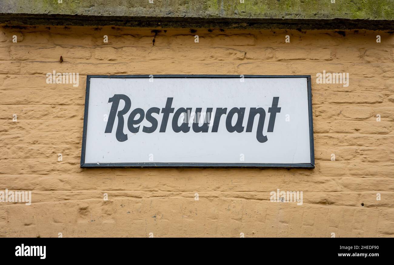 Panneau de restaurant sur un ancien bâtiment à la façade beige Banque D'Images