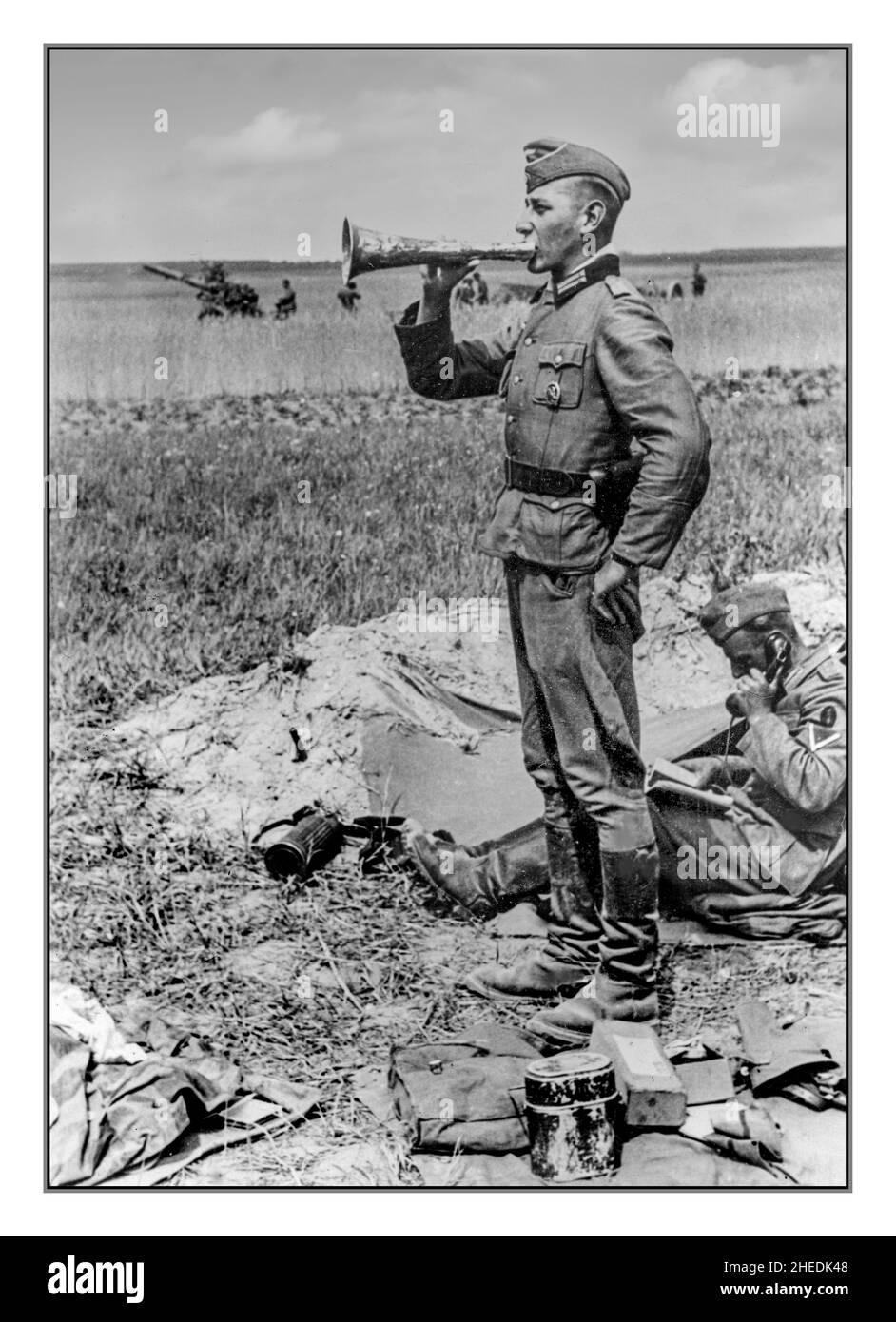WW2 opération Barbarossa Un officier allemand Nazi Wehrmacht donne l'ordre par l'intermédiaire d'un mégaphone sur le front oriental.Derrière lui, un soldat assis parle au téléphone sur le terrain. Banque D'Images