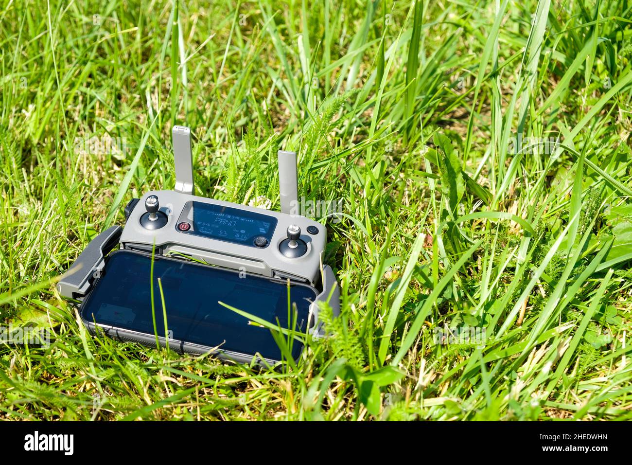 Le contrôleur de la console de drone avec le téléphone portable est couché sur l'herbe.Photographie aérienne de la nature. Banque D'Images