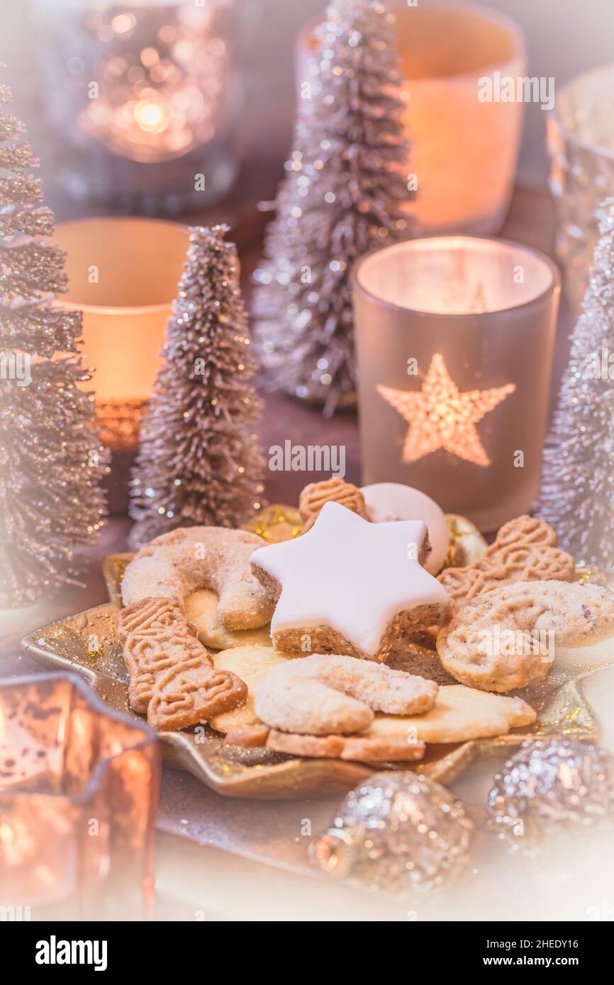 Biscuits de Noël sur une assiette en forme d'étoile avec décoration de noël et bougies, verticales Banque D'Images