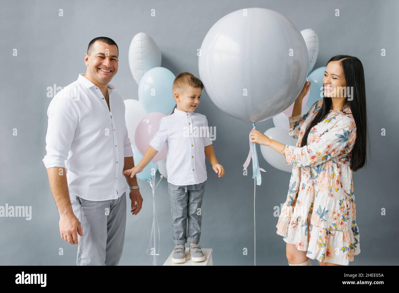 Fête de révélation de genre. Belle famille élégante avec un bébé pop un  ballon pour découvrir le sexe de l'enfant à naître dans la famille Photo  Stock - Alamy