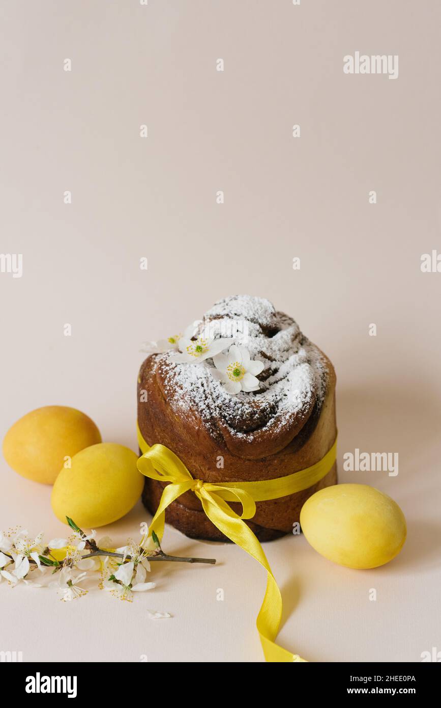Gâteau de Pâques kraffin à la cannelle et au sucre en poudre.Gros plan d'une tarte maison avec des œufs de couleur jaune et de caille Banque D'Images