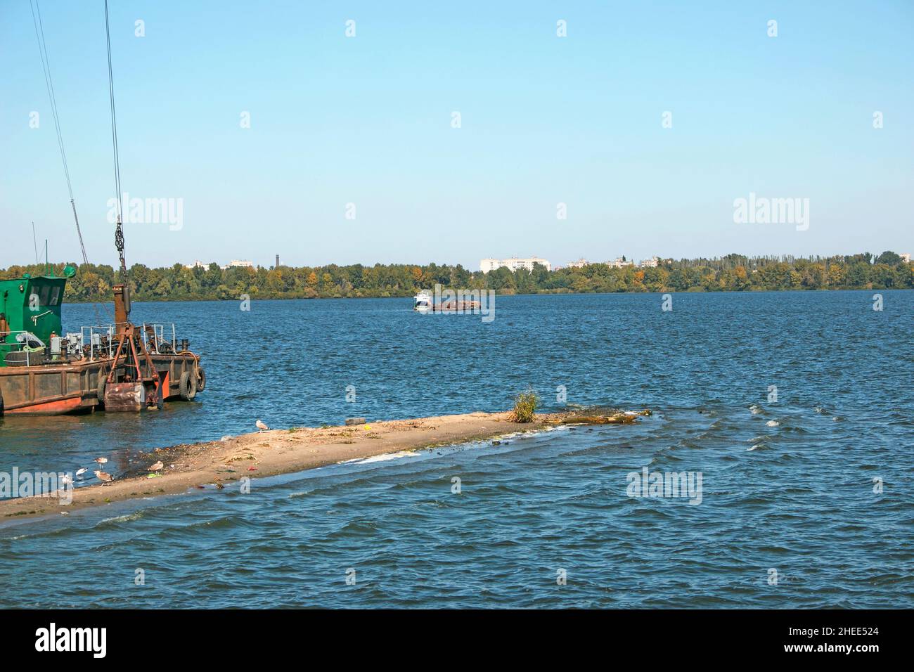 Nettoyage de l'île nouvellement formée des déchets industriels sur le Dniepr avec une drague.Une barge avec un remorqueur prend les ordures.Concept d'écologie. Banque D'Images