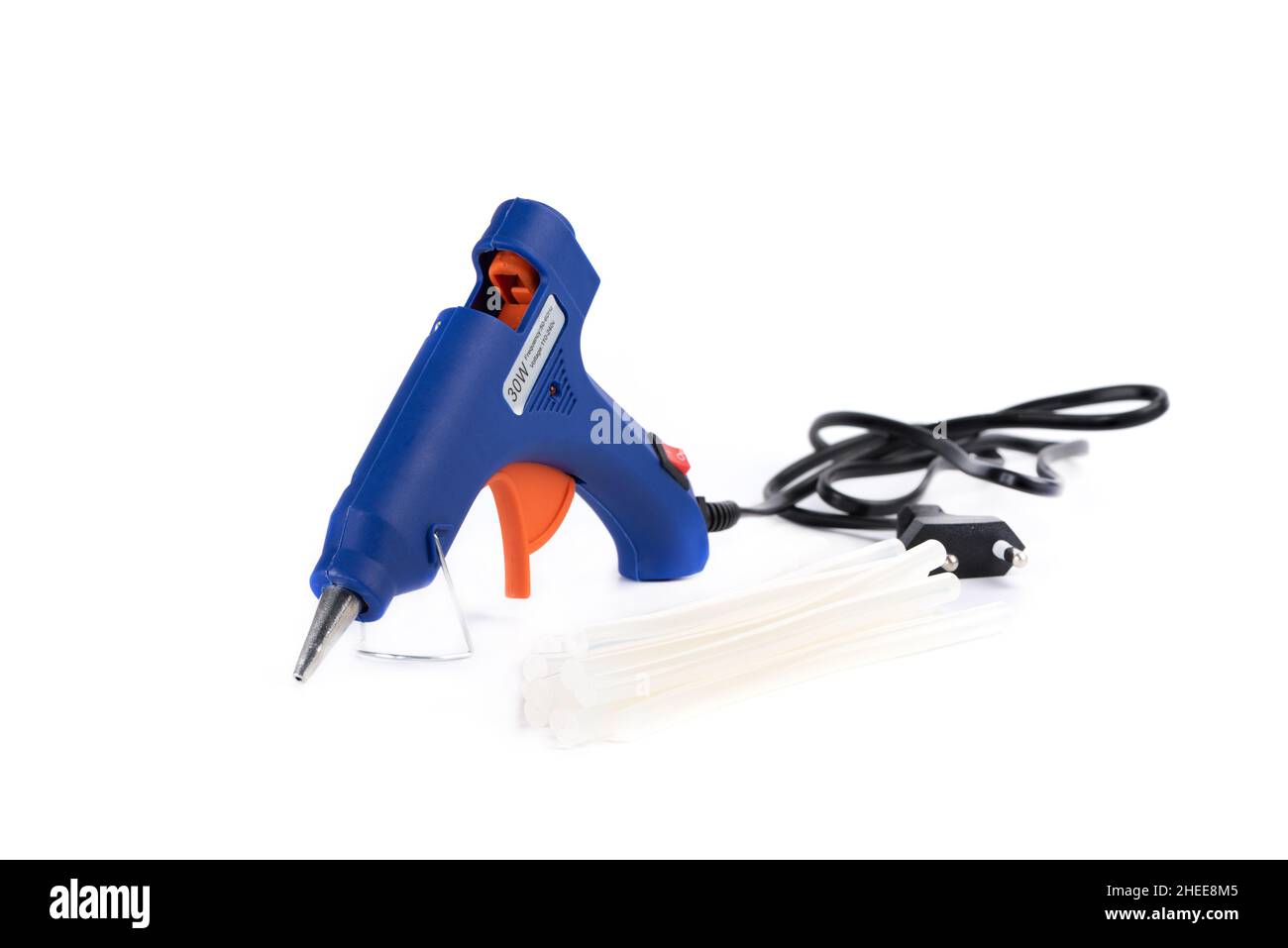 Pistolet à colle à chaud électrique et tiges de pistolet sur fond blanc.Pistolet à colle bleu sur fond blanc Banque D'Images