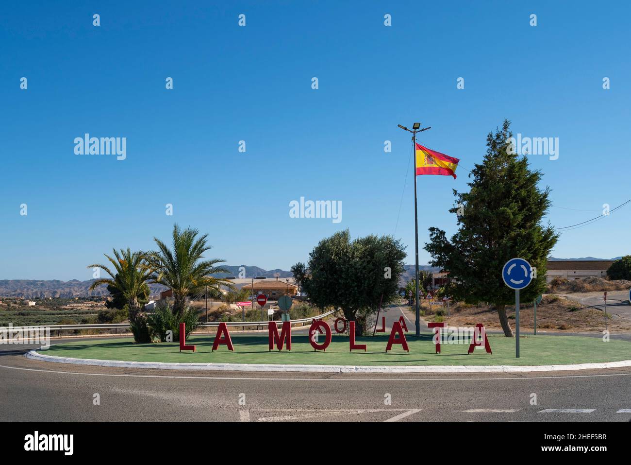 La Molata signe de la ville sur un rond-point en quittant la ville espagnole d'Albox, Almeria, Andalousie, Espagne, avec drapeau espagnol.La Molata a une population de 19 habitants Banque D'Images