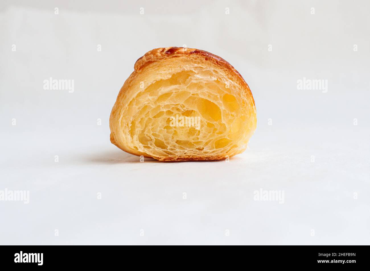 Coupe de croissant sur un papier parchemin.Pâte feuilletée prête à consommer.Concept de boulangerie maison et copieux. Banque D'Images