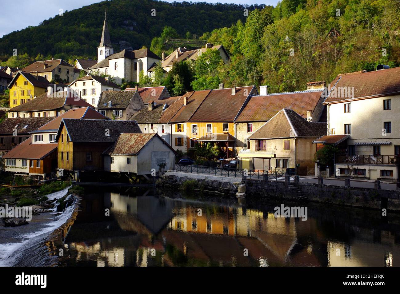 Photographie couleur du village de Lod avec église sur une colline reflétée dans la rivière Loue, Franche-Comté, Jura, France, Europe, 2018. Banque D'Images