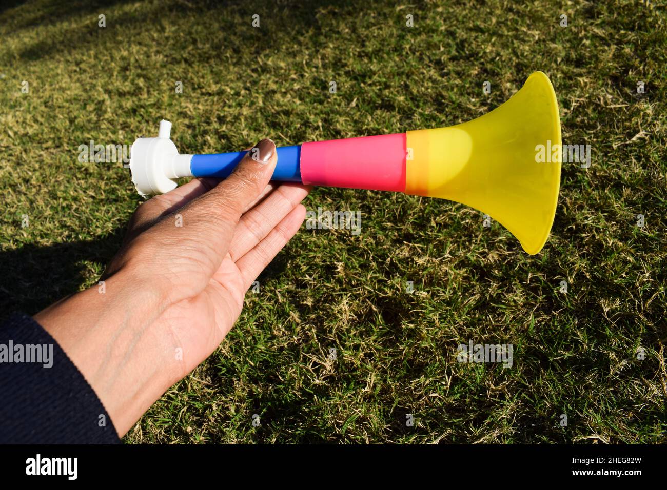 Personne tenant la trompette en forme de sifflet sifflet siffleur connu  sous le nom de Pipudi ou pipudo dans gujarati.Soufflé pendant le festival  de cerf-volant d'Uttarayan ou Makar sankranti i Photo Stock -