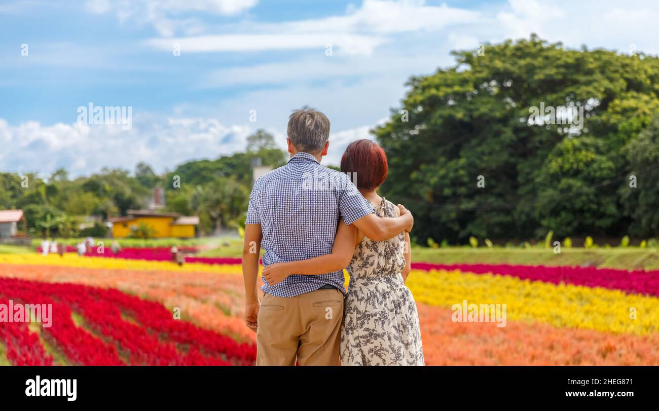 Heureux couple asiatique retraité détendu dans le jardin de fleurs Banque D'Images