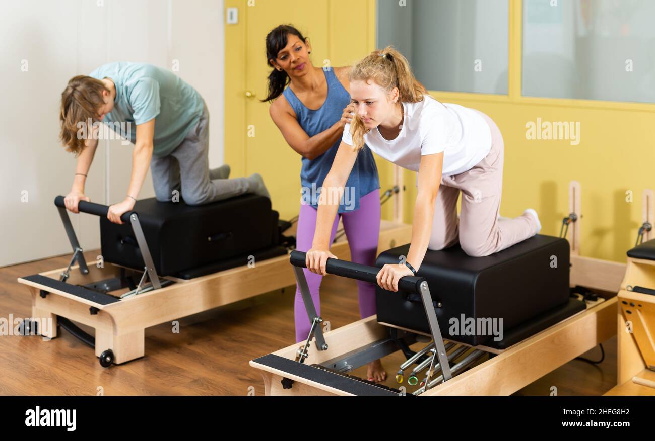 Adolescents d'entraînement pilates dans la salle de gym avec entraîneur Banque D'Images