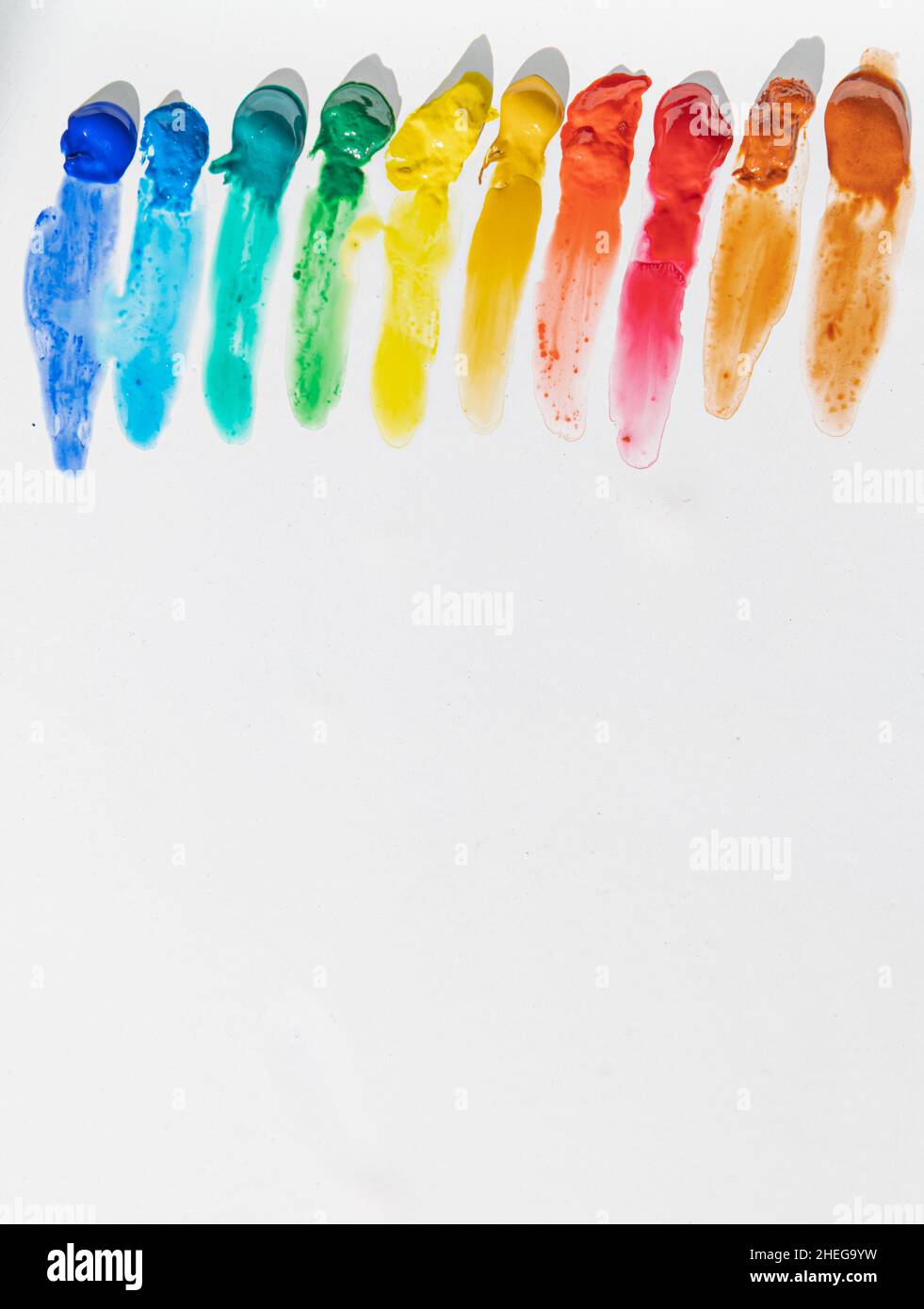 Aquarelle dans les couleurs de l'arc-en-ciel qui coule sur fond blanc avec espace de texte Banque D'Images
