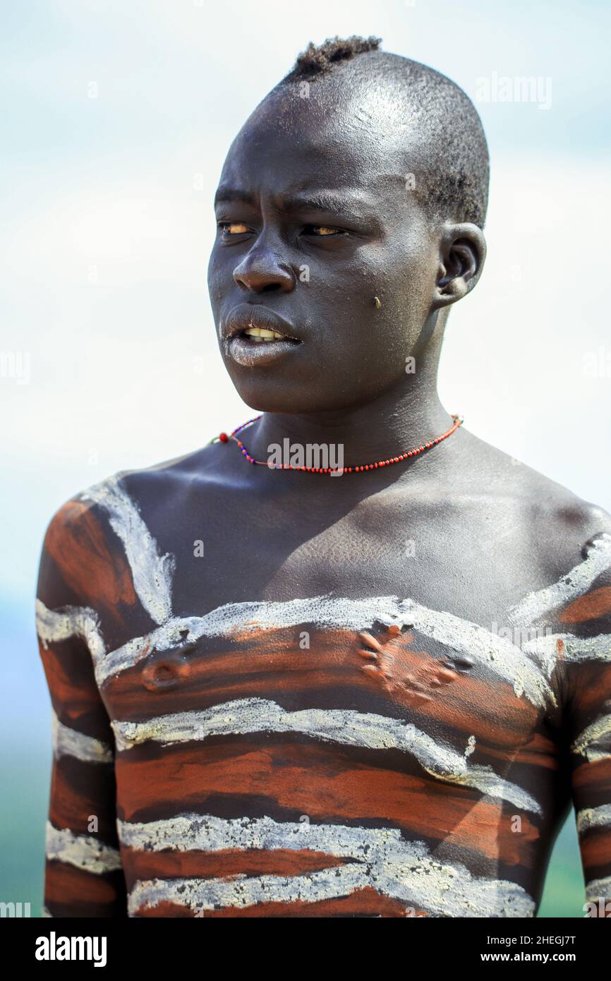 Vallée de la rivière Omo, Éthiopie - 29 novembre 2020 : Portrait du jeune homme africain avec corps peint dans le village de la tribu locale de Mursi Banque D'Images