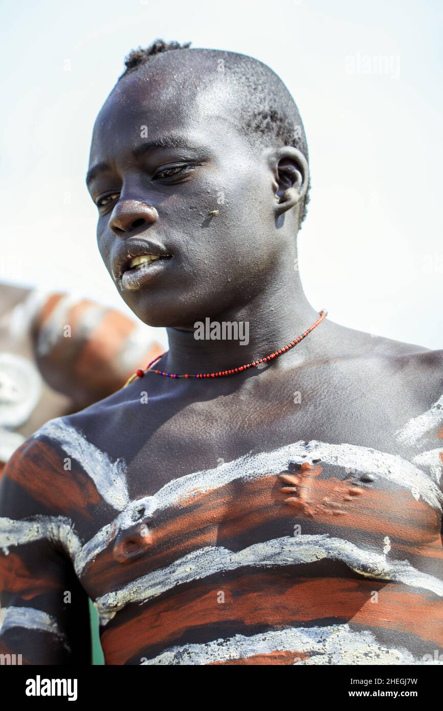 Vallée de la rivière Omo, Éthiopie - 29 novembre 2020 : Portrait du jeune homme africain avec corps peint dans le village de la tribu locale de Mursi Banque D'Images