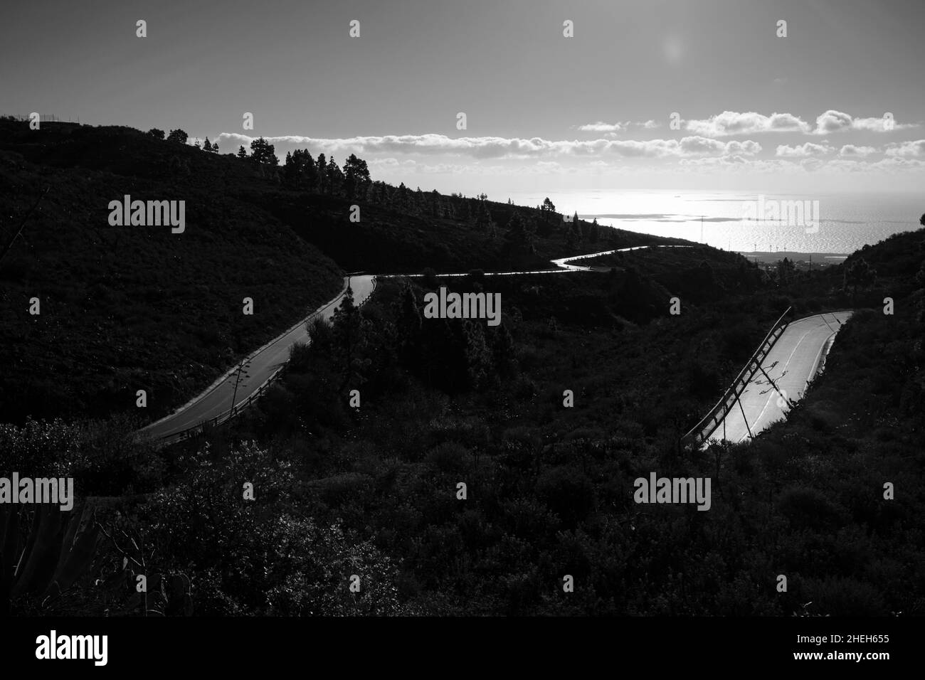 Surface de route mouillée rétro-éclairée avec vue sur la côte de Granadilla depuis Las Vegas, Tenerife, Iles Canaries, Espagne Banque D'Images
