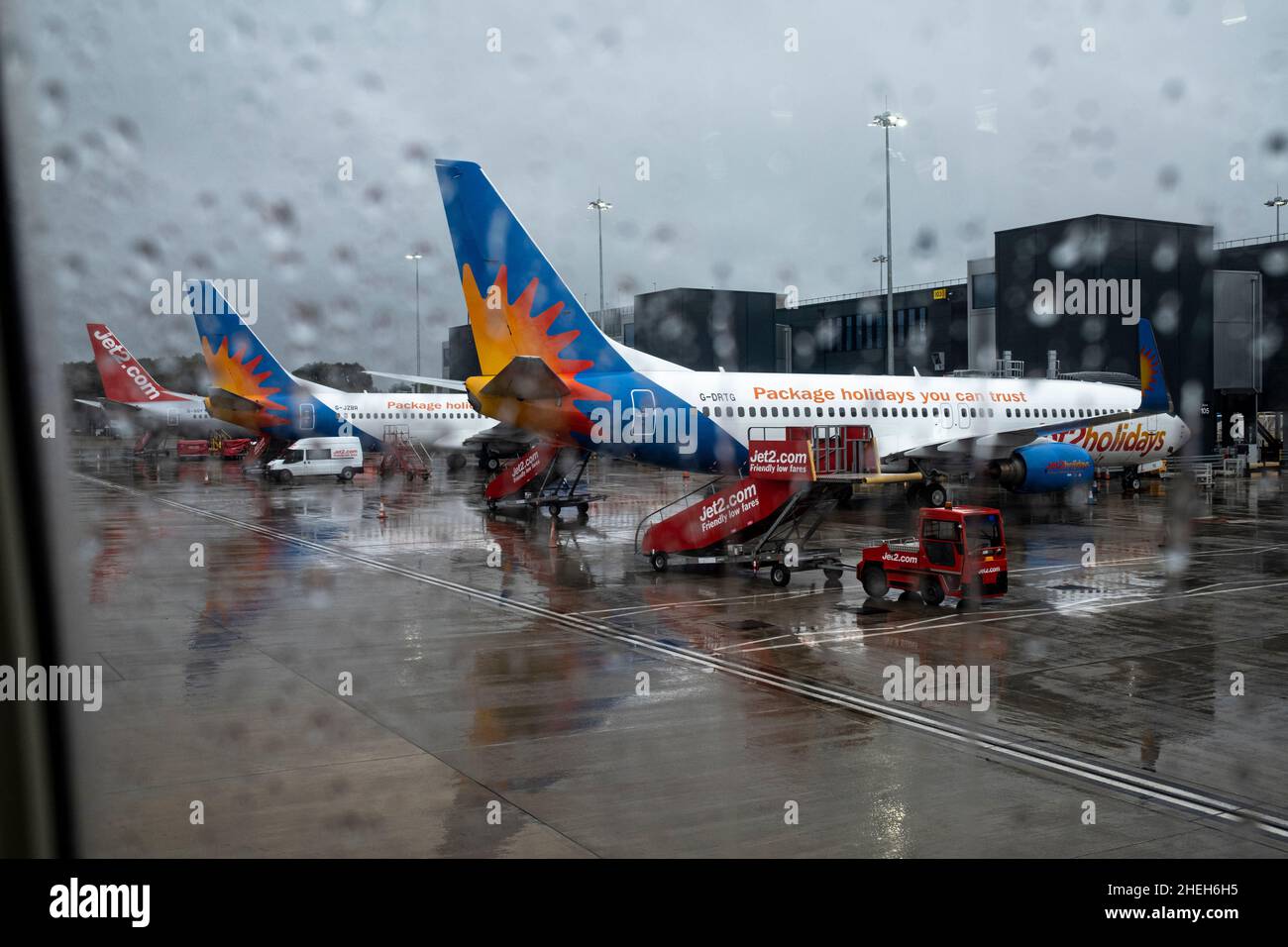 Avion de vacances Jet 2 vu à travers la fenêtre d'un avion sous la pluie sur le sol à l'aéroport de Manchester, Angleterre, Royaume-Uni Banque D'Images