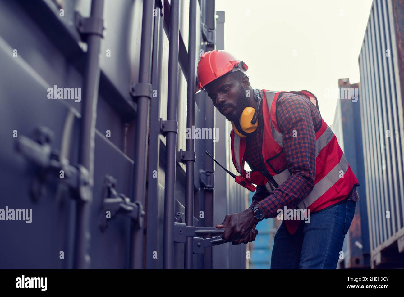 Les travailleurs afro-américains ouvrent les conteneurs pour inspection et vérifient que les réparations ont été effectuées dans les conteneurs. Banque D'Images