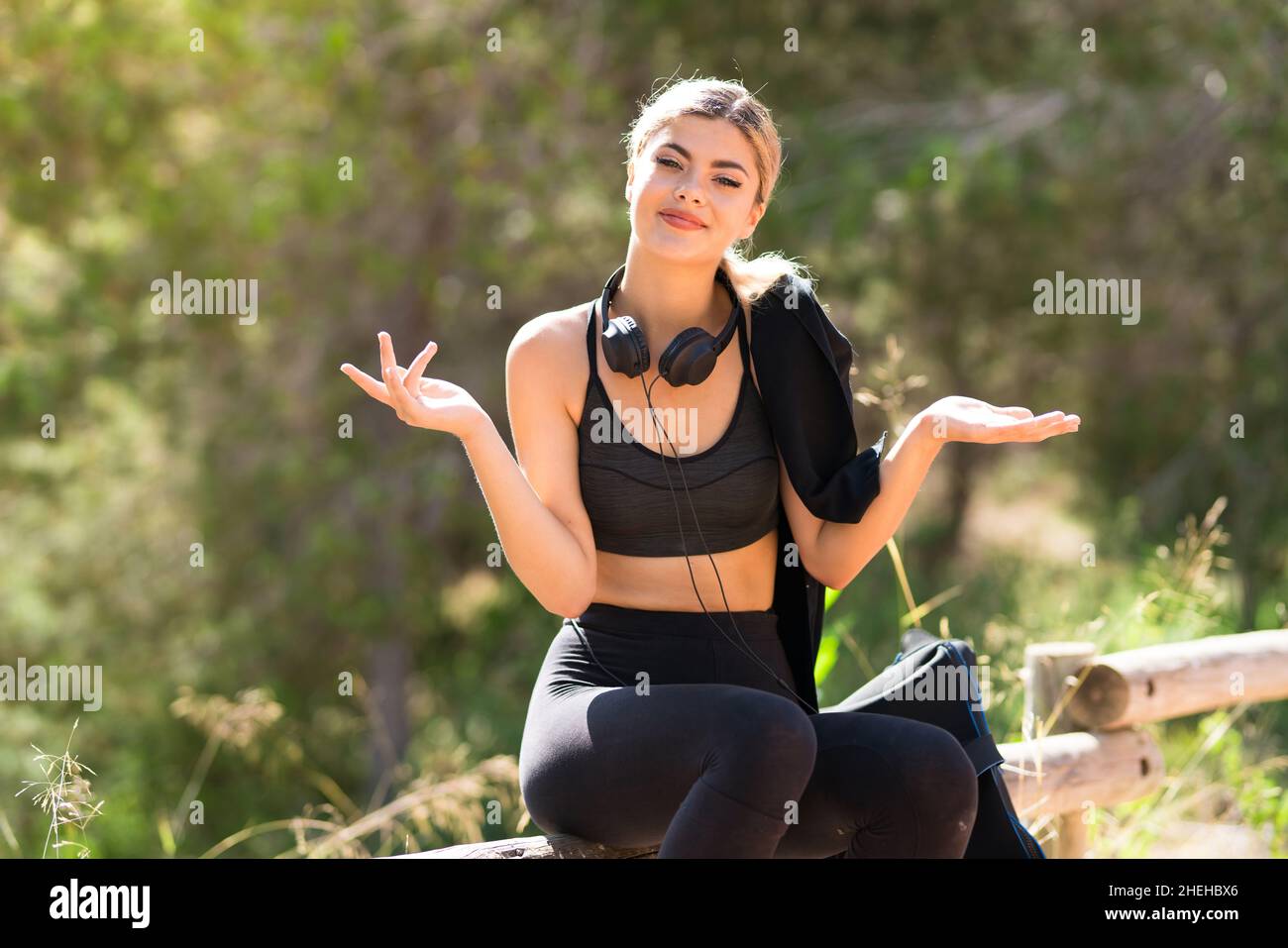 Adolescente sport fille faisant du sport à l'extérieur ayant des doutes tout en levant les mains Banque D'Images