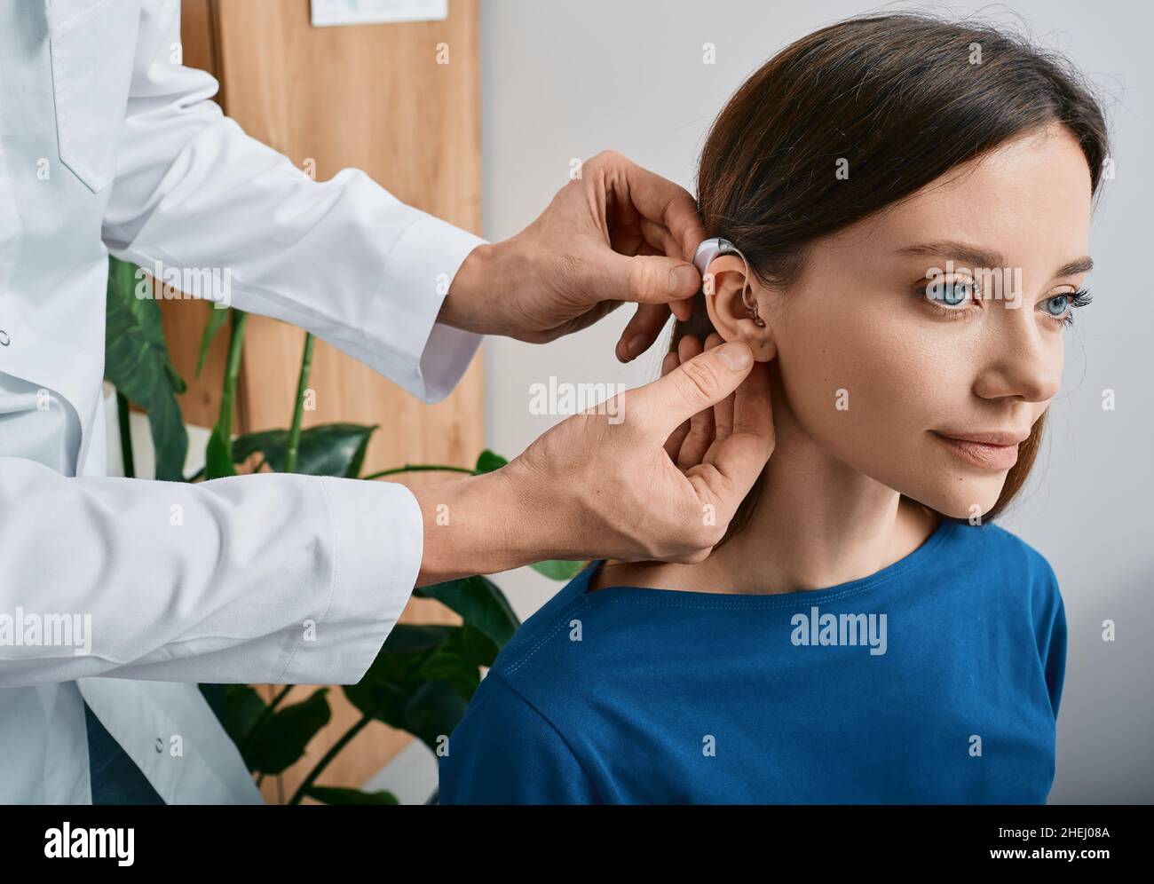Installation d'une prothèse auditive sur l'oreille d'une femme à la clinique d'audition, vue rapprochée, vue latérale.Traitement de la surdité, solutions auditives Banque D'Images