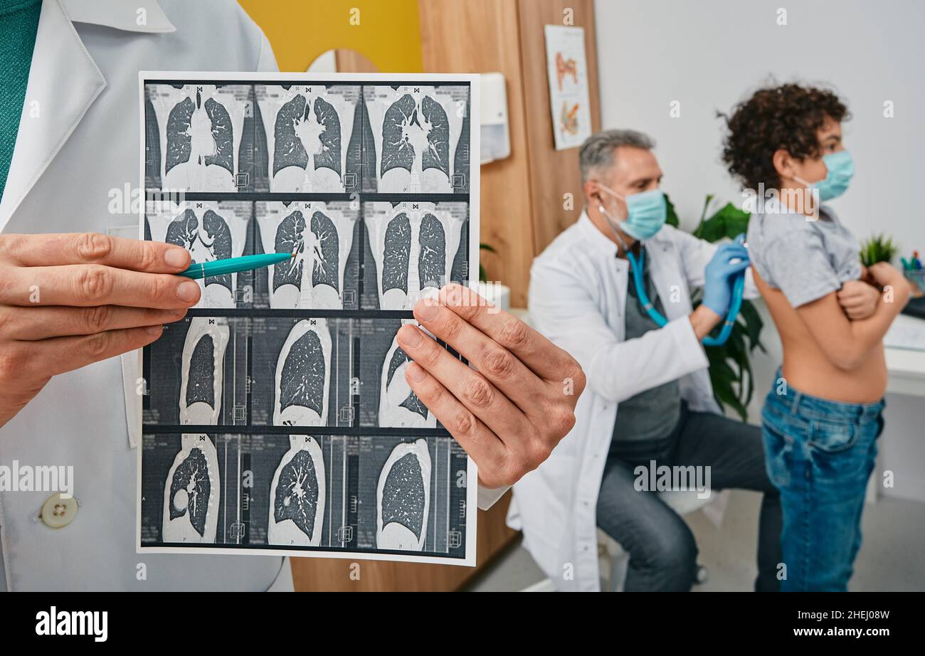 Auscultation des poumons et du système respiratoire.Pédiatre écoutant les poumons du garçon à l'aide d'un stéthoscope.Pulmonologieist montrant l'acquisition CT des poumons dans pendant Banque D'Images