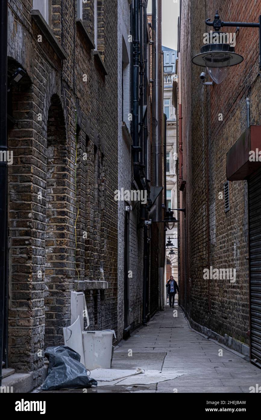 Un piéton marchant le long d'une ruelle étroite dans une ville européenne.Brydges place, Covent Garden, Londres, Royaume-Uni Banque D'Images