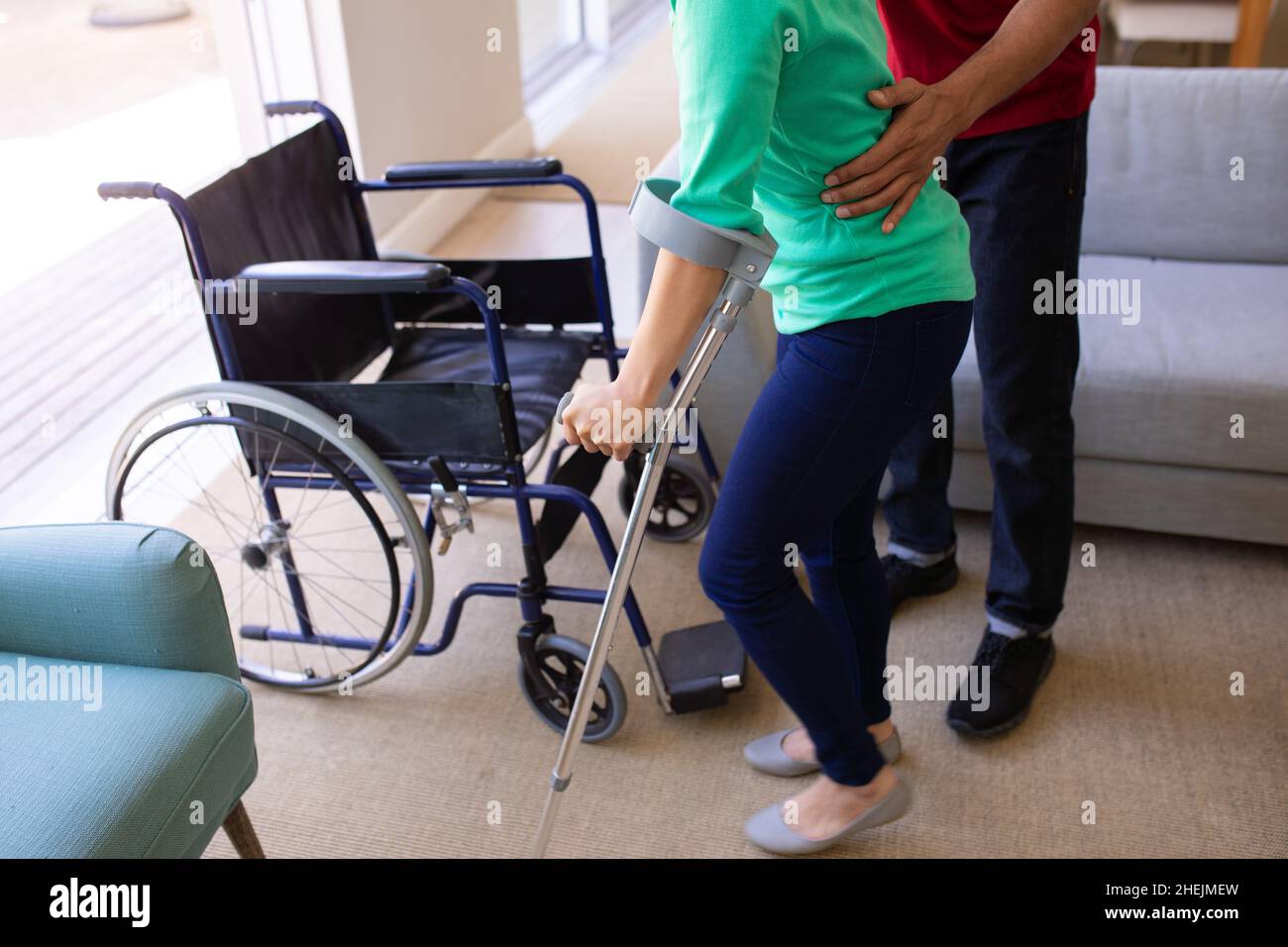 Section médiane de l'homme afro-américain aidant sa femme handicapée à