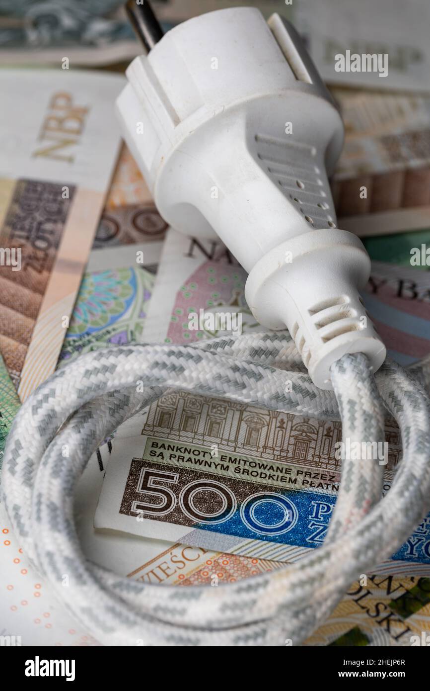 Câble électrique avec prise et de nombreux billets polonais.Hausse du prix  de l'électricité en Pologne.Photo prise sous une lumière artificielle douce  Photo Stock - Alamy