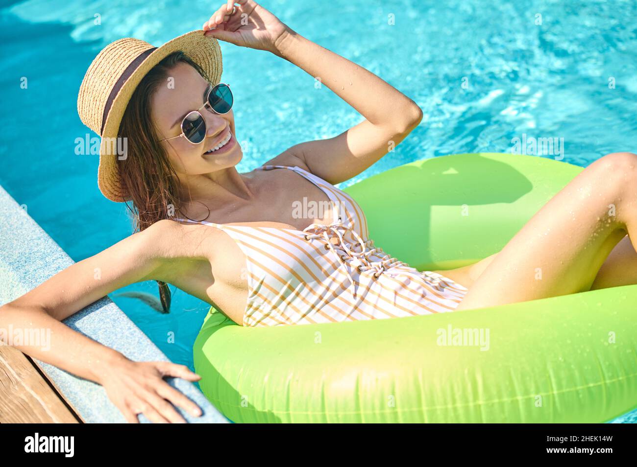 Mince jeune femme dans des coups de soleil nageant dans un tube Banque D'Images