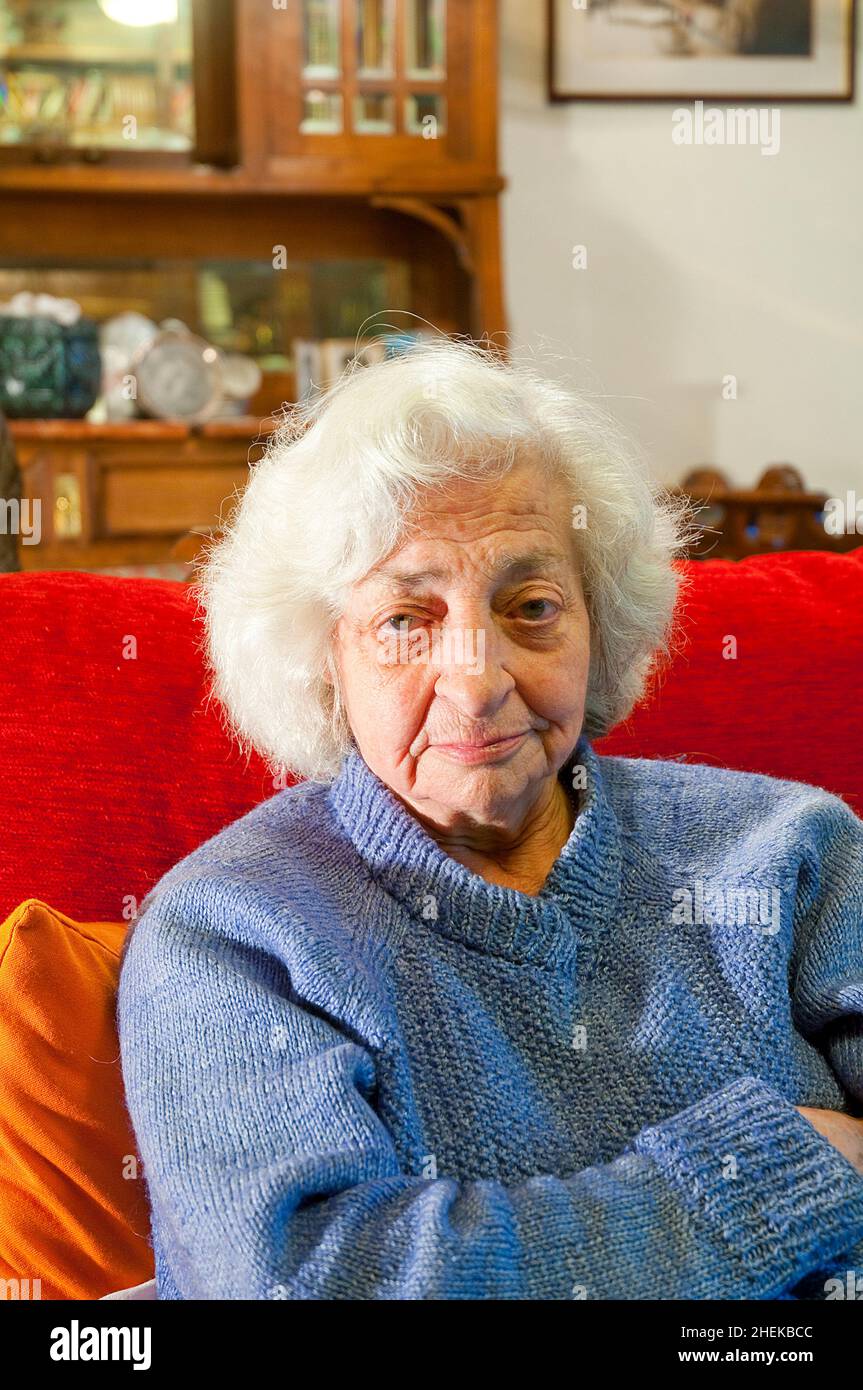 Portrait de la vieille femme à la maison, regardant l'appareil photo. Banque D'Images