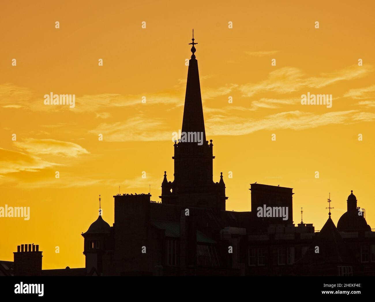 Édimbourg, Écosse, Royaume-Uni.11th janvier 2022.À l'approche du coucher du soleil, température de 7 degrés centigrade avec une lueur orange au-dessus du centre-ville.La flèche de l'église convertie aujourd'hui connue sous le nom de centre de divertissement Hub au sommet du Royal Mile dans le centre avec d'autres architecture sur le toit autour de lui.Credit: Archwhite/Alamy Live News. Banque D'Images