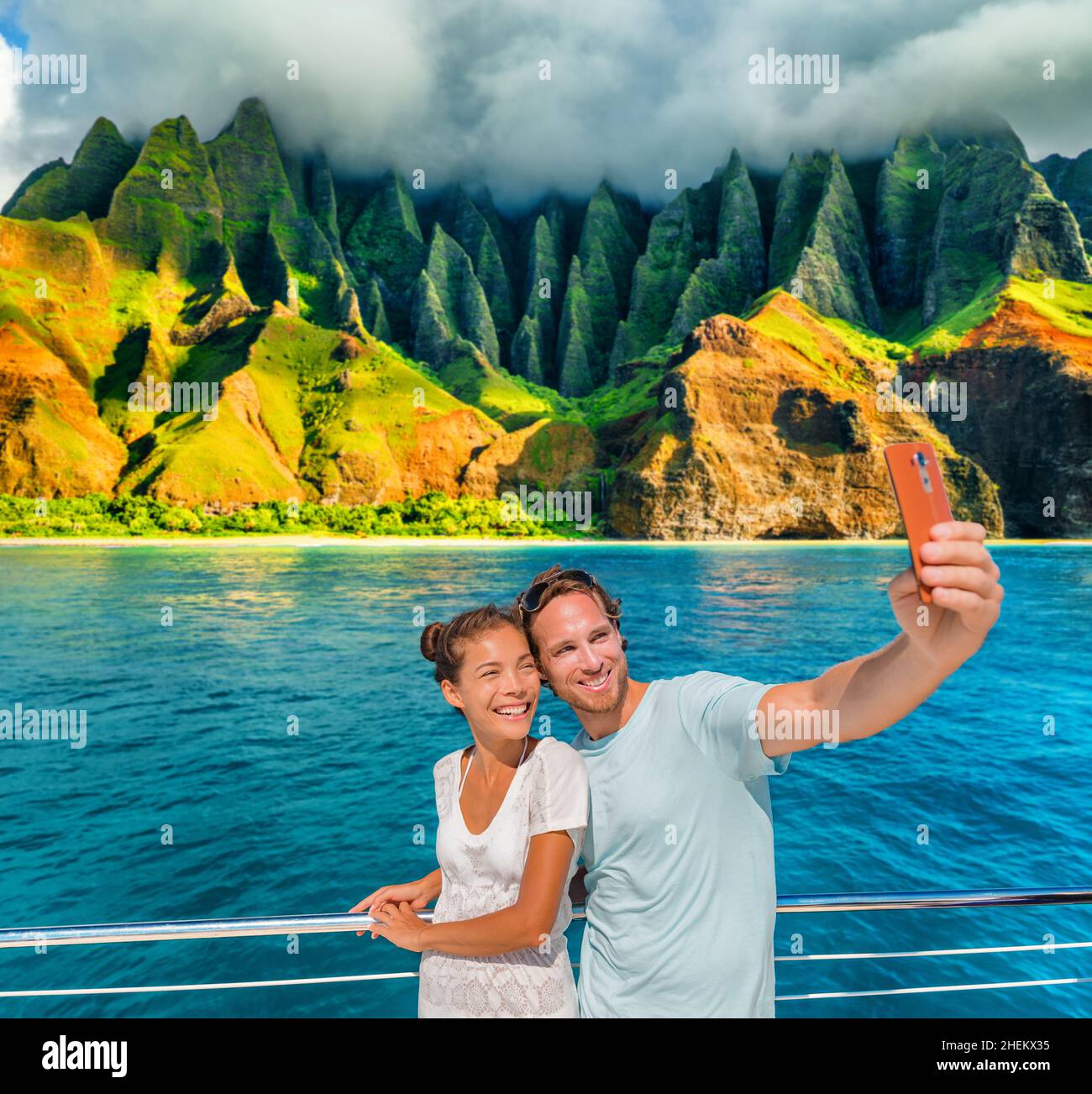 Hawaii bateau de croisière couple touristes prenant photo selfie avec téléphone à la côte Na Pali, Kauai île, USA vacances d'été Voyage.Bonne femme asiatique Banque D'Images