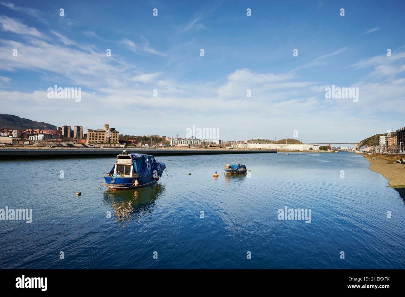 Vue sur le fleuve Nervion en premier plan et la zone industrielle de Zorroza avec un ciel bleu avec des nuages, Gascogne, pays Basque, Espagne, Europe Banque D'Images