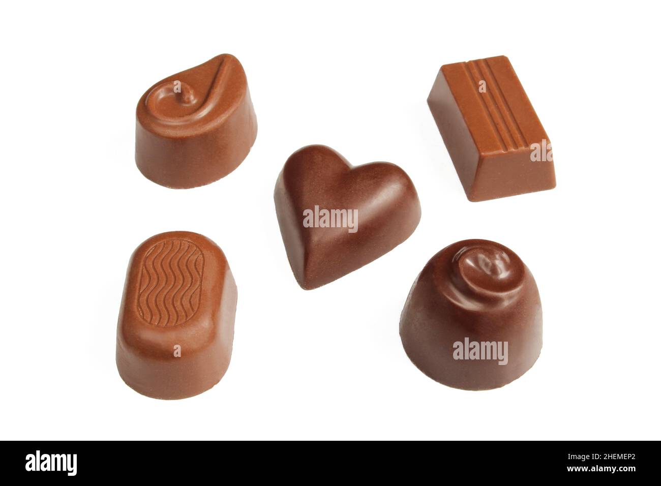 Cinq pralines de chocolat de forme différente isolées sur fond blanc Banque D'Images