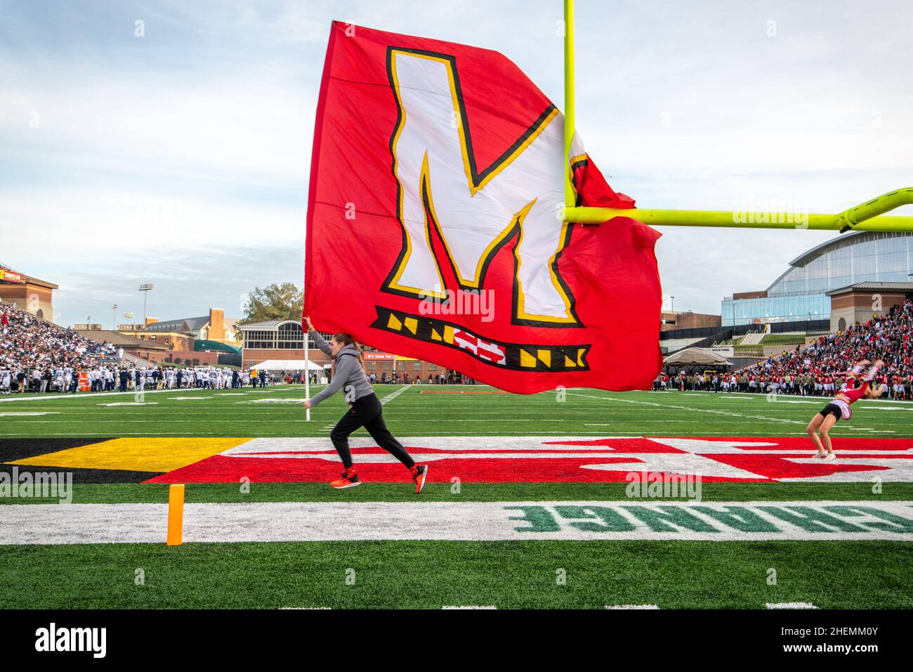 Un coureur agitant un drapeau de l'Université du Maryland à travers la zone finale Banque D'Images