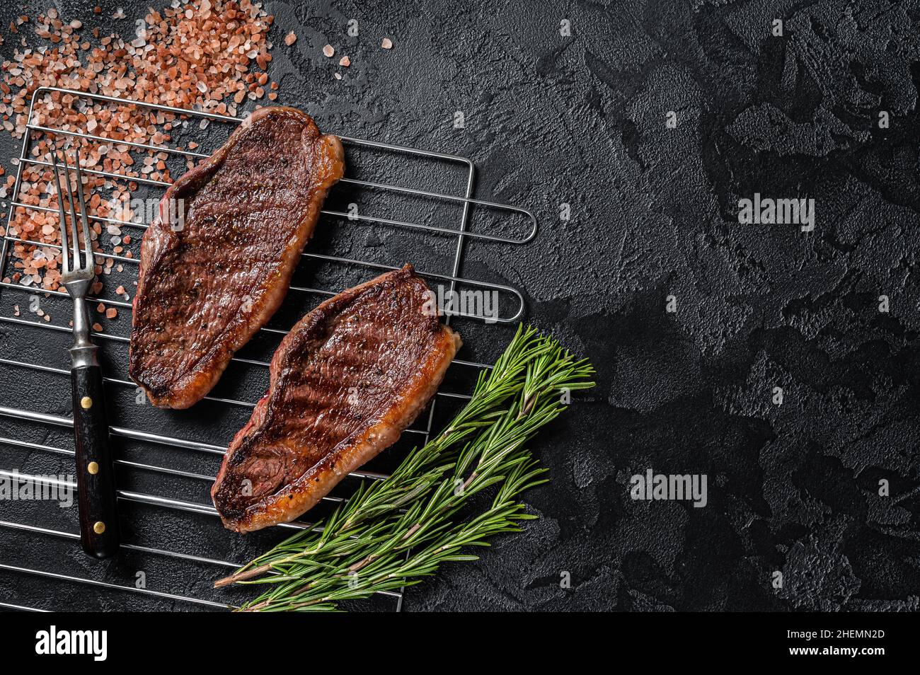 Rôti de chapeau grillé au barbecue ou bifteck de bœuf au sirloin du haut, viande frite sur le gril.Arrière-plan noir.Vue de dessus.Copier l'espace Banque D'Images