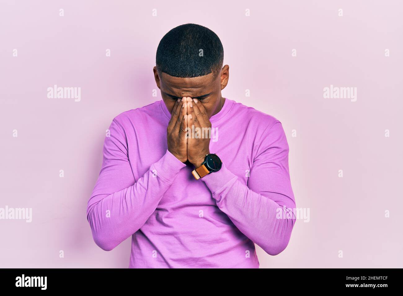 Jeune homme noir portant un pull rose décontracté avec une expression  triste couvrant le visage avec les mains en pleurant. Concept de dépression  Photo Stock - Alamy