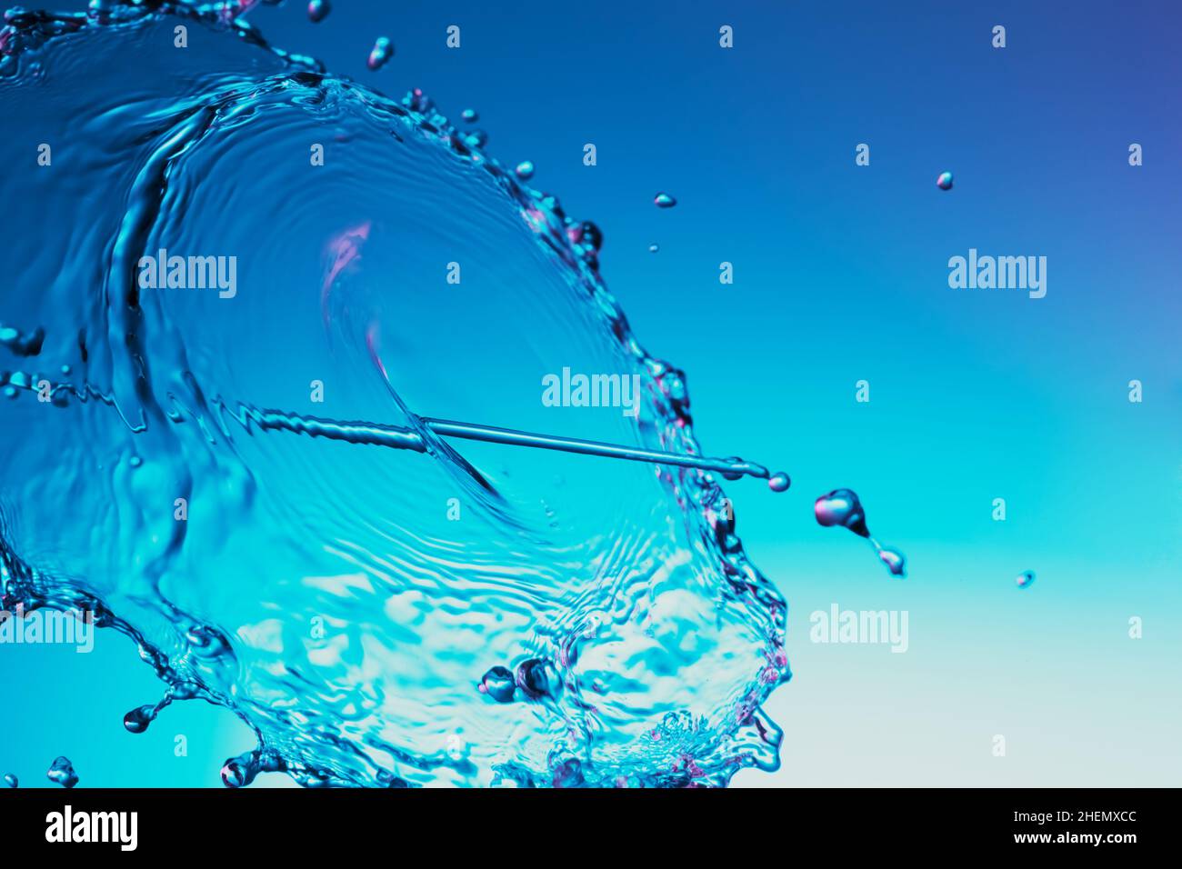 Projection de liquide d'eau claire sur fond bleu Banque D'Images