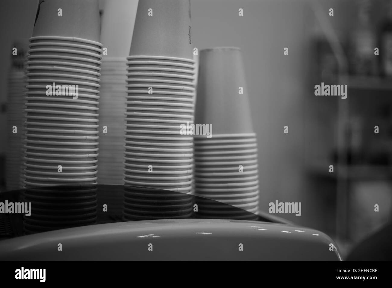 Les tasses à café en papier empilées se tiennent sur la machine à café Banque D'Images Les tasses à café en papier empilées se tiennent sur la machine à café Banque D'Images