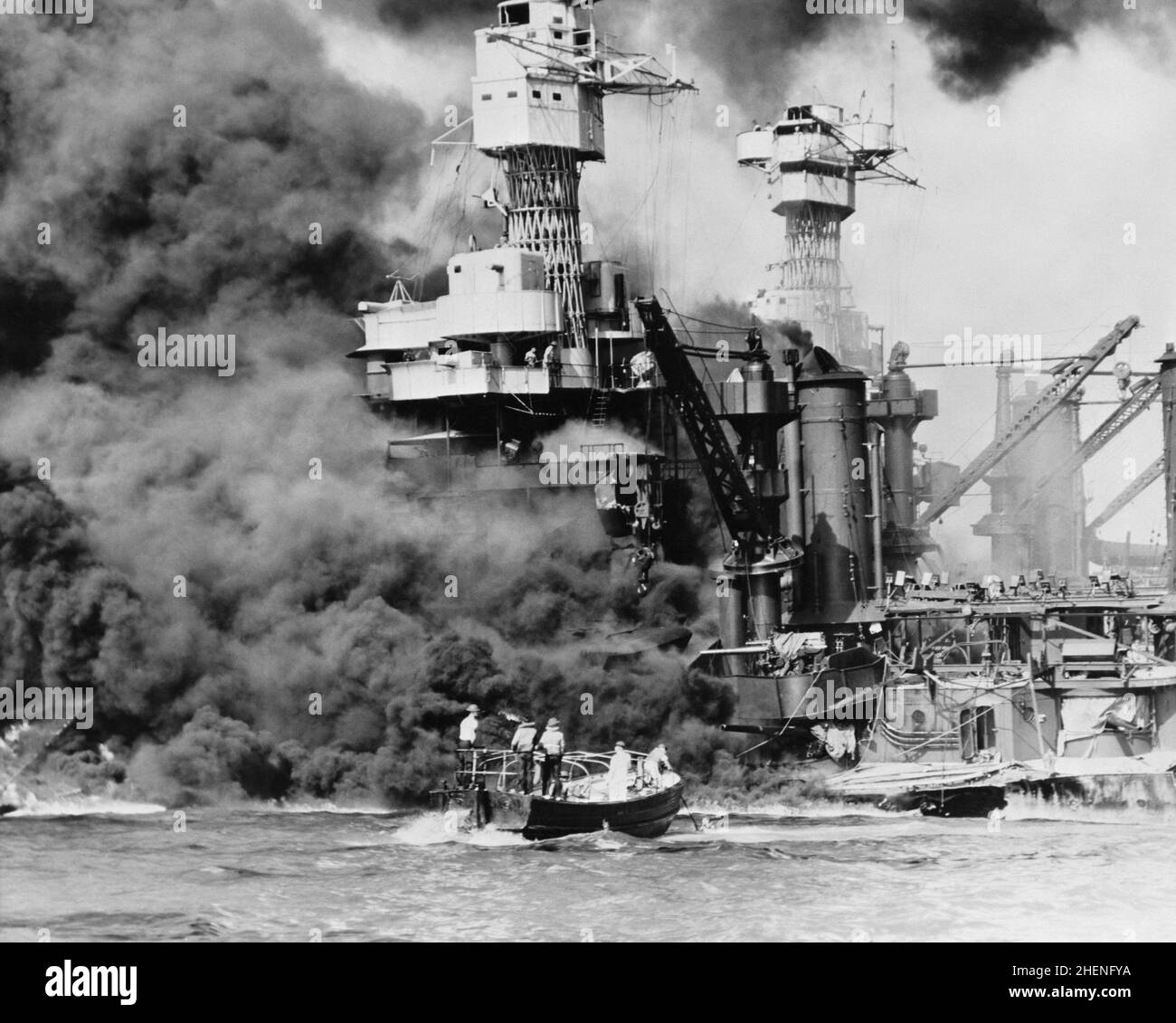 Un tir de sauvetage passant devant l'épave brûlante de l'USS West Virginia pendant l'attaque sur Pearl Harbor Banque D'Images