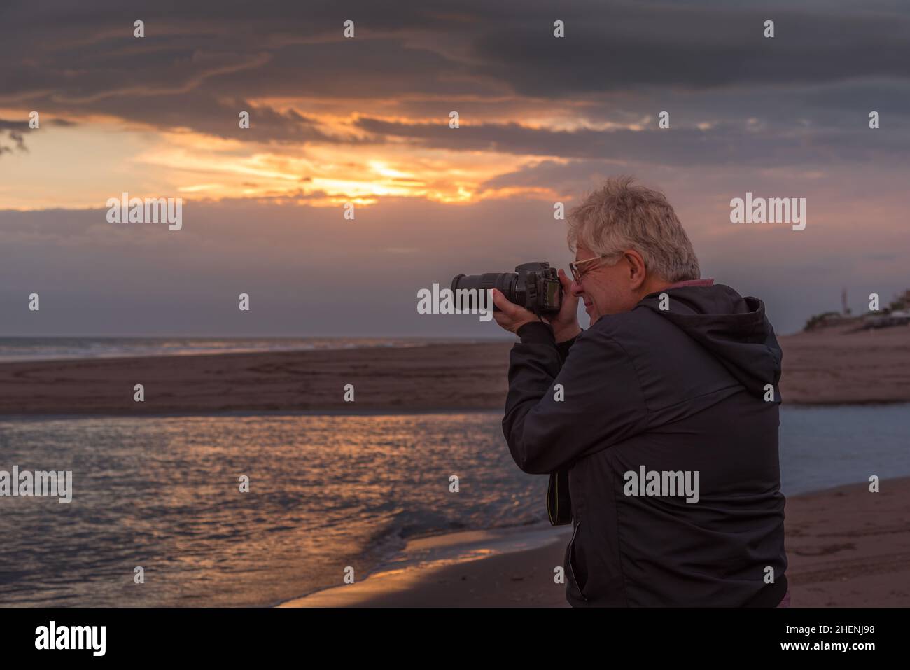 Homme adulte mature prenant une photo au coucher du soleil Banque D'Images