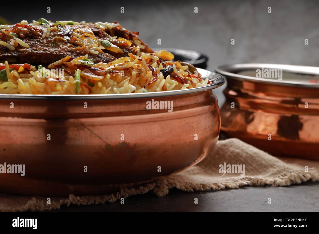 Poisson Biriyani, poisson de style indien du Sud biriyani arrangé traditionnellement dans un navire en laiton avec ritha comme plat d'accompagnement. Banque D'Images