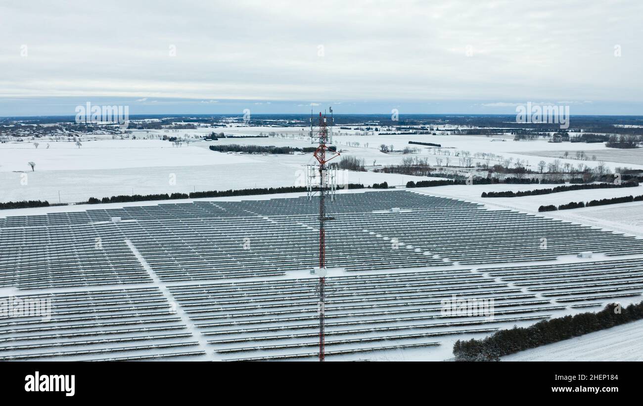Une vue aérienne de niveau sur le sommet d'une tour de cellules dans une zone rurale, est vue par une journée d'hiver enneigée. Banque D'Images