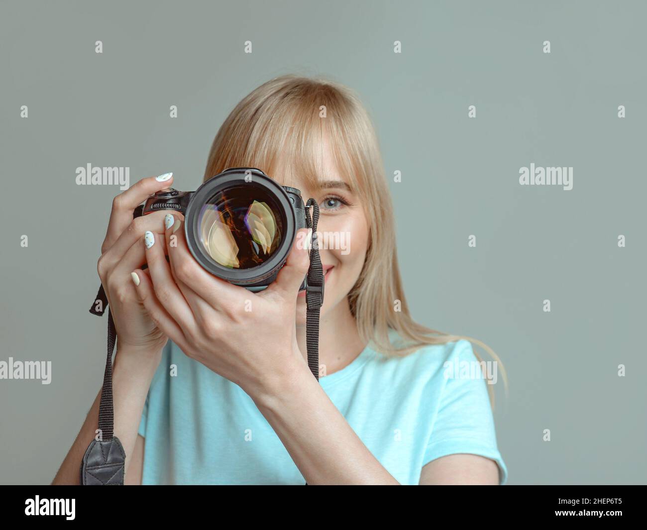 blonde élégante femme joyeuse photographe en lunettes et tenant un appareil photo.Passe-temps, travail, tournage Banque D'Images