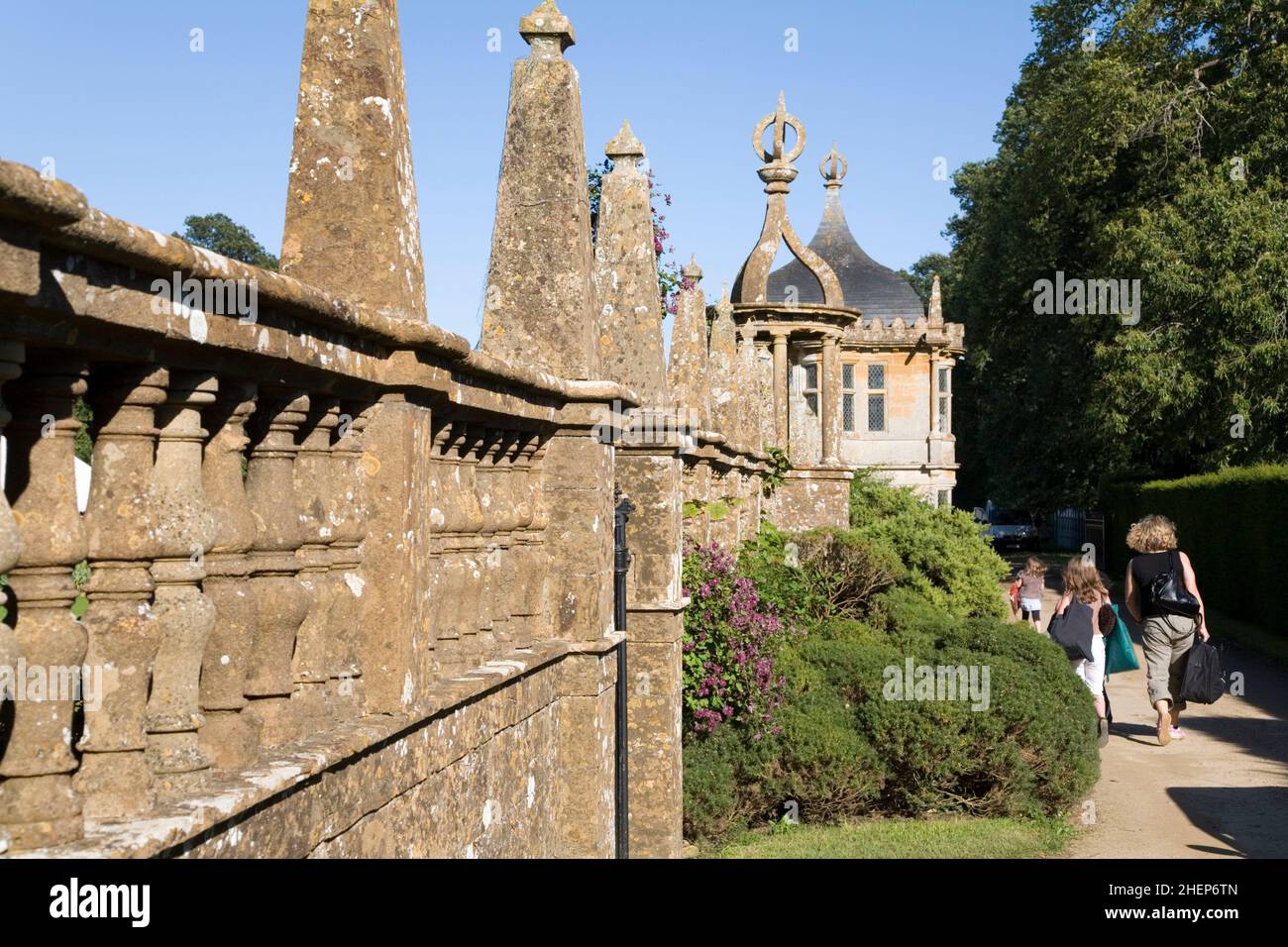 Un groupe de famille avec dos à la caméra, marcher le long d'un chemin et mur ornemental à la Maison de Montacute dans Somerset, Angleterre Banque D'Images