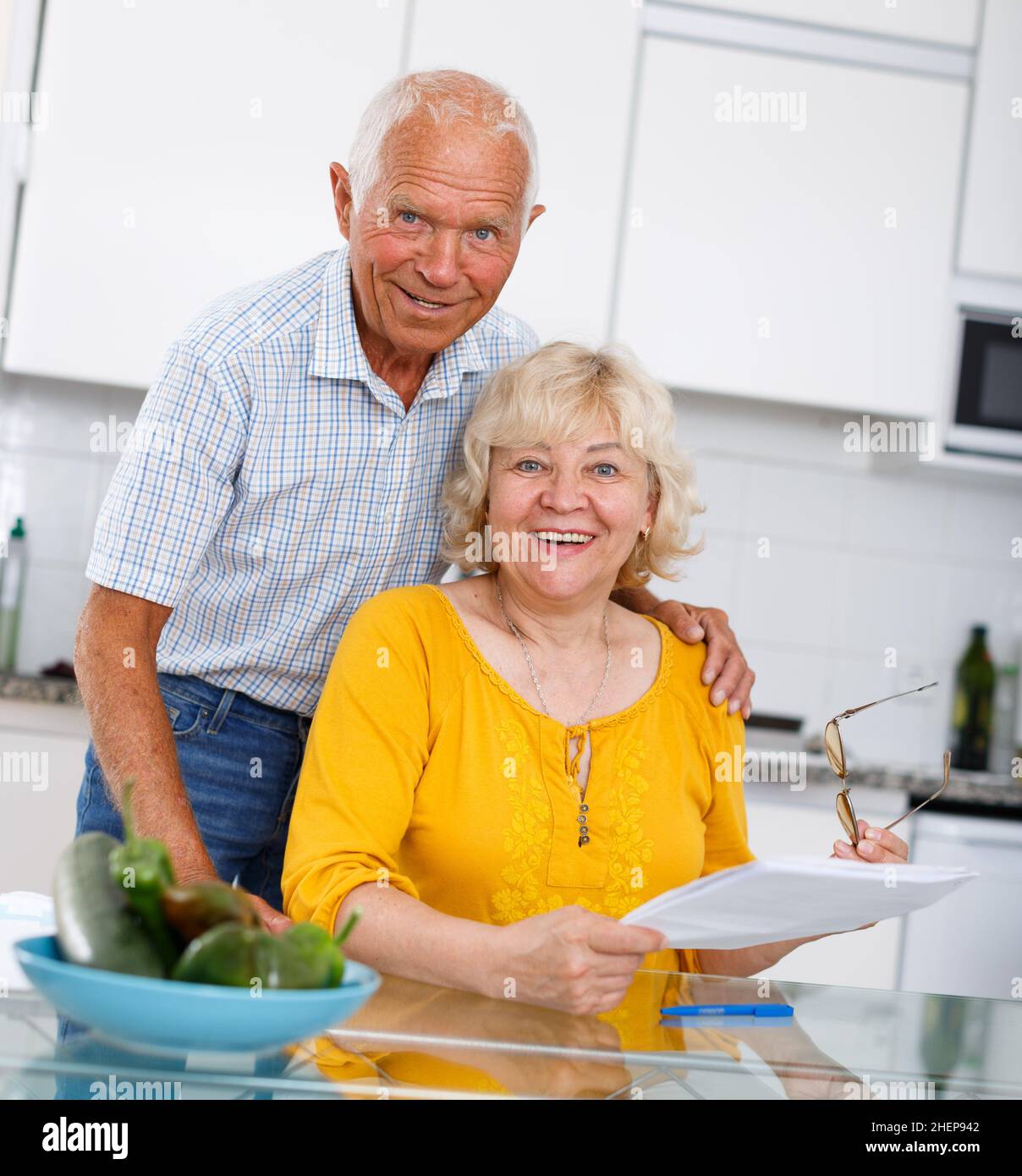 Couple de famille mature assis à la table de cuisine avec des documents Banque D'Images