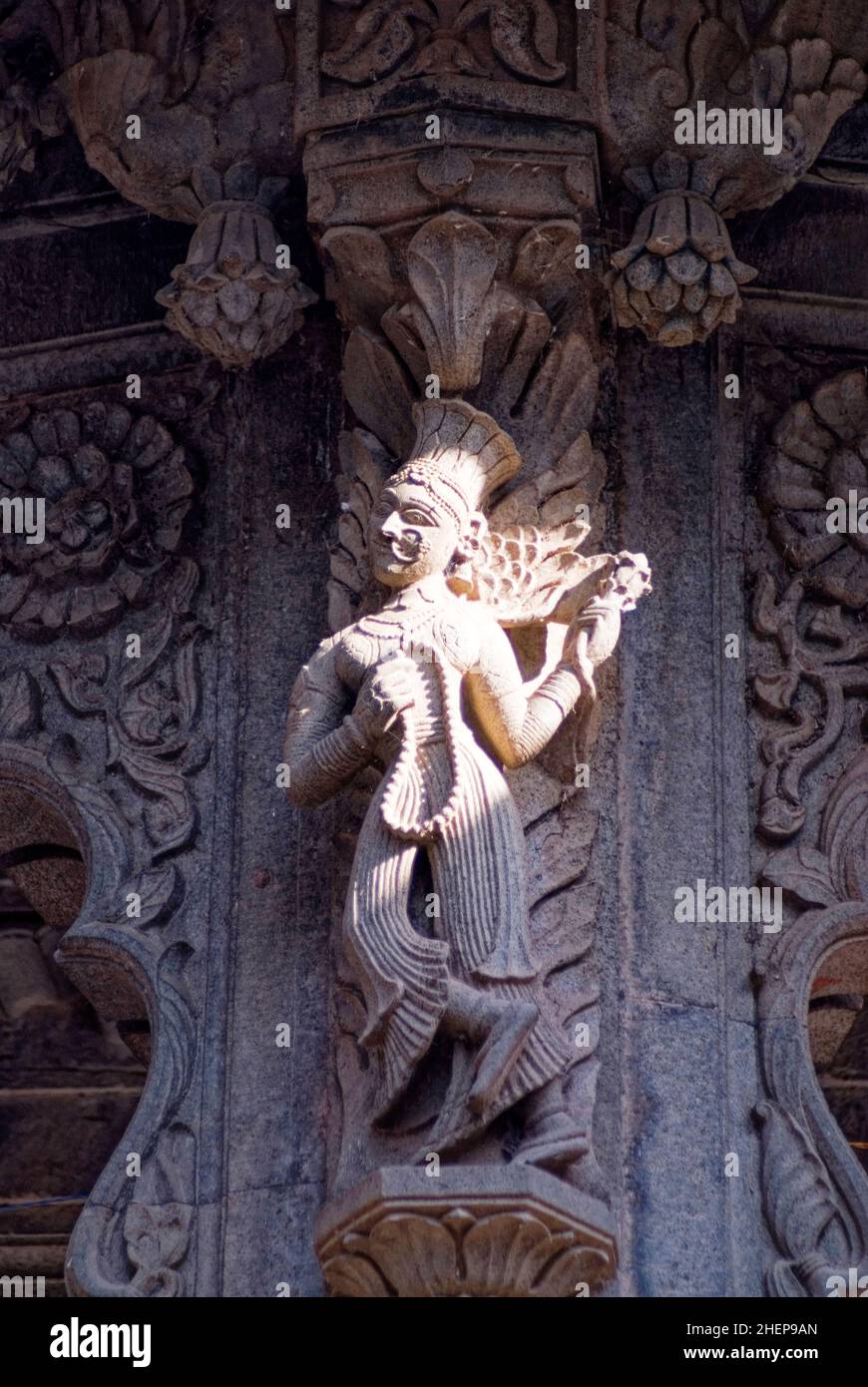 Une femme avec le chapeau de plumes sur sa tête sculptée en pierre sur le mur de chhatri (Mémorial) à Maheshwar Banque D'Images