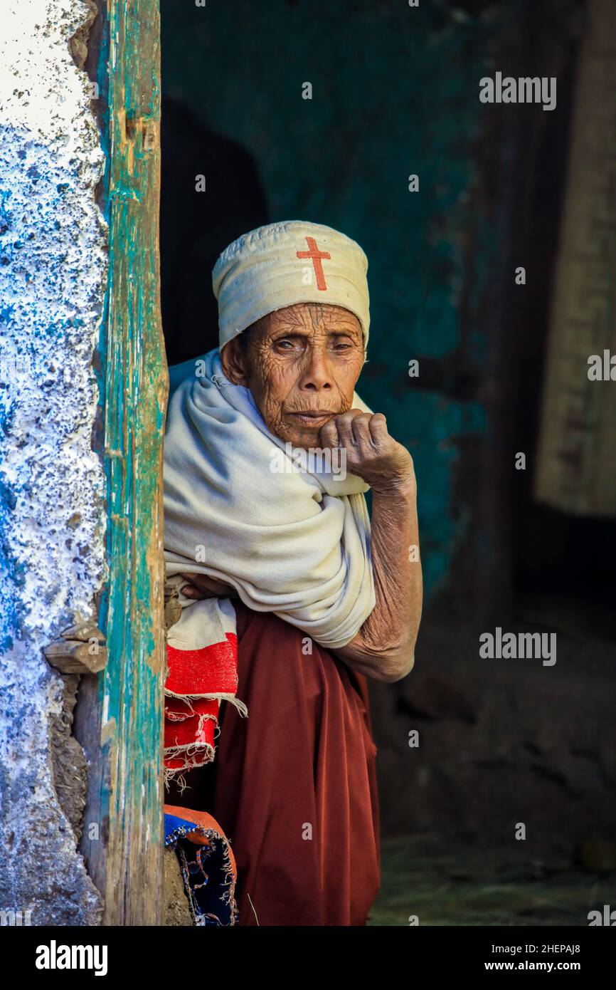 Vieille femme éthiopienne avec Croix-Rouge sur le Cap regardant de la porte Banque D'Images