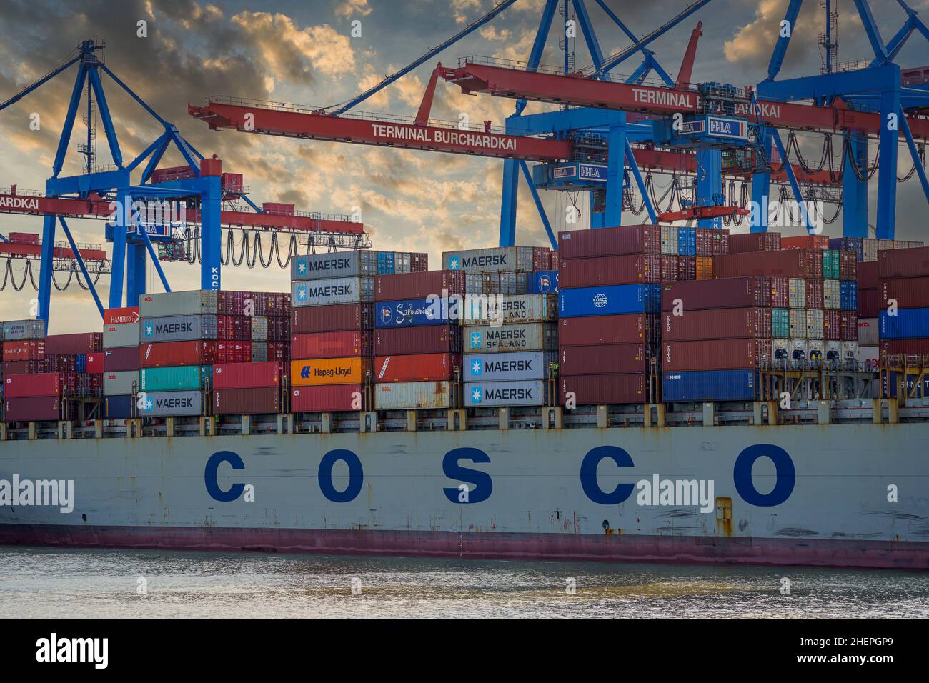 Ein Containerschiff der COSCO Reederei am Burchardkai à Hambourg, avec à la tête Abenddämmerung Entladen Banque D'Images
