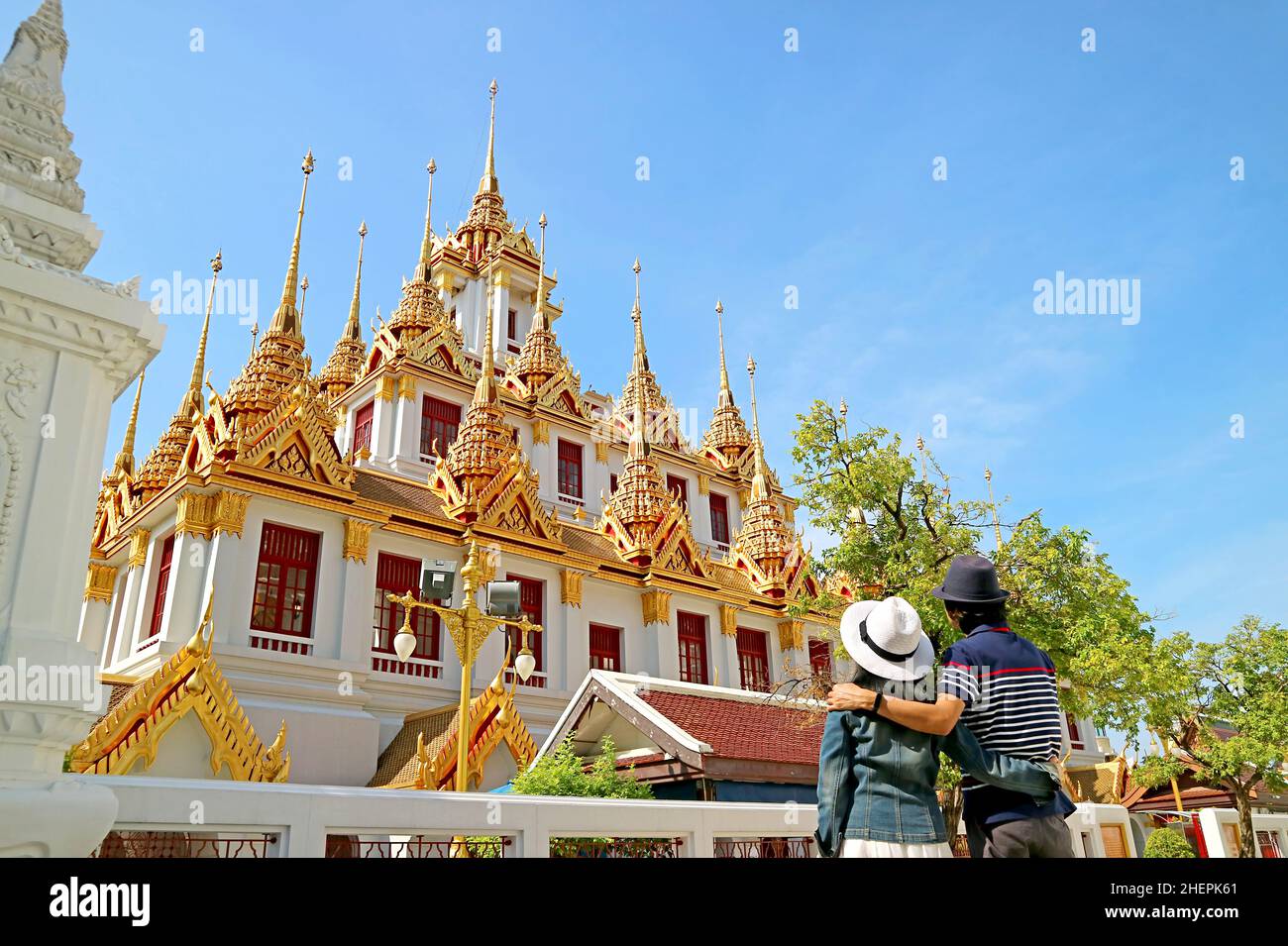 Couple visitant le magnifique Loha Prasat (château de fer) orné de 37 pointes d'or à l'intérieur du temple de Wat Ratchanatdaram, la vieille ville de Bangkok, Thaïlande Banque D'Images