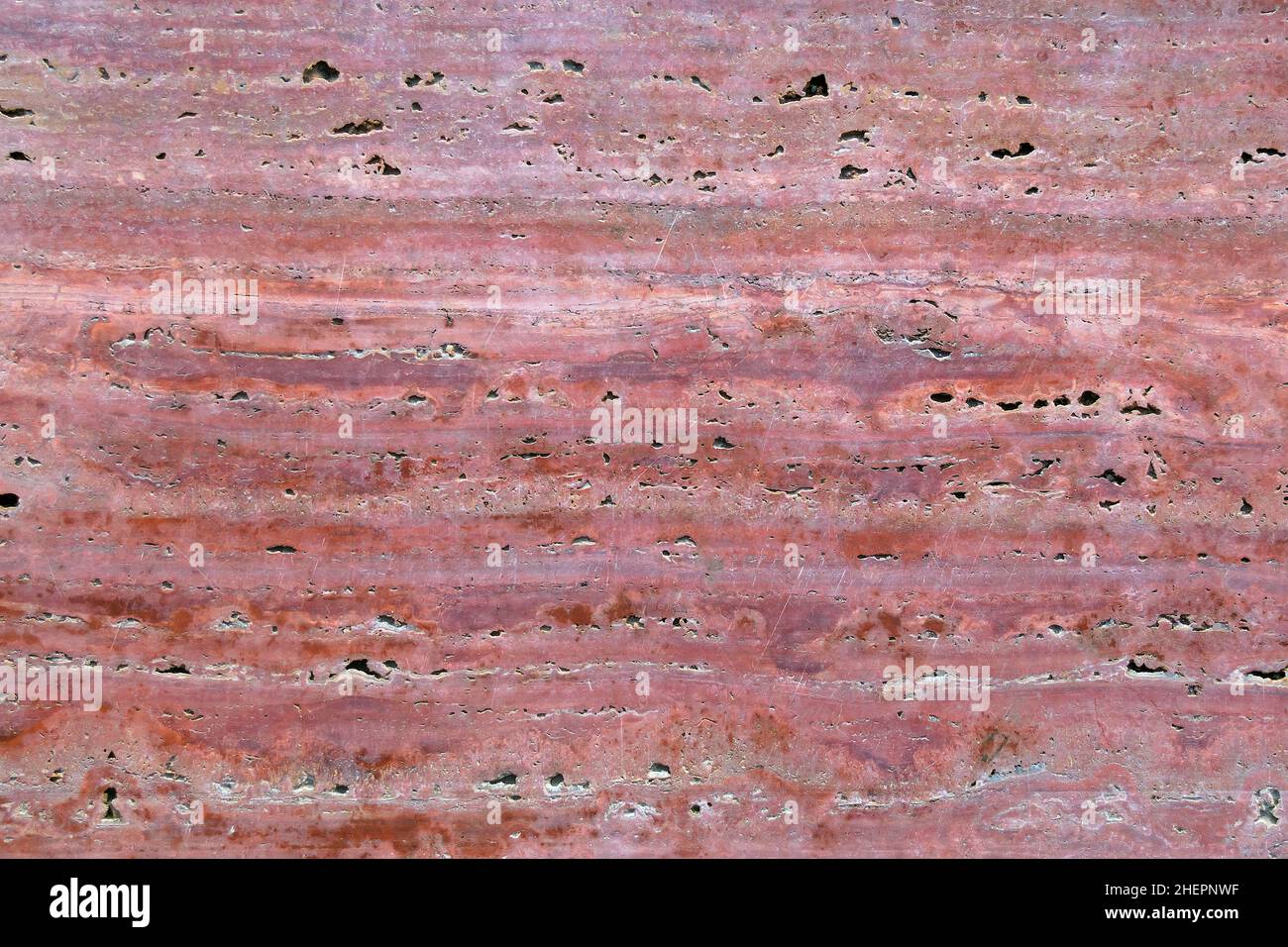 coupe longitudinale de granit rose avec éclaboussures.La surface d'une ancienne dalle de granit veiné. Banque D'Images